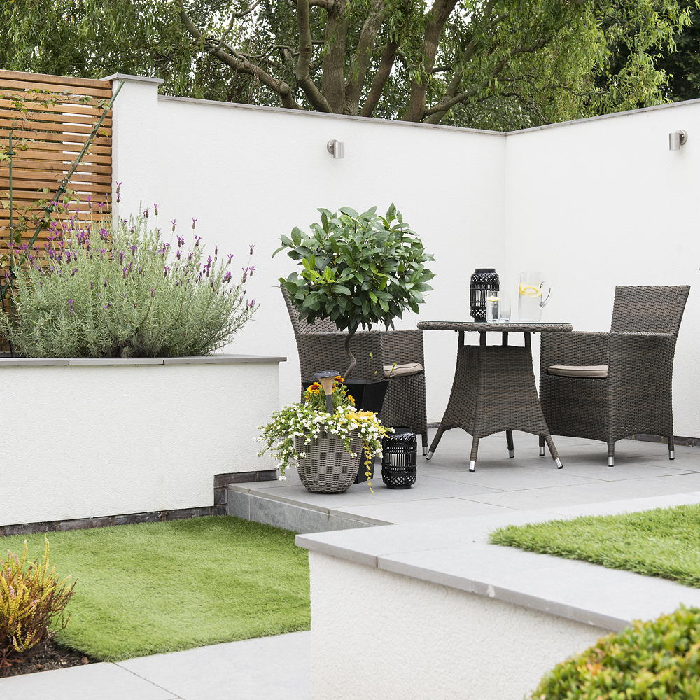 White walled garden with artificial grass and bistro set